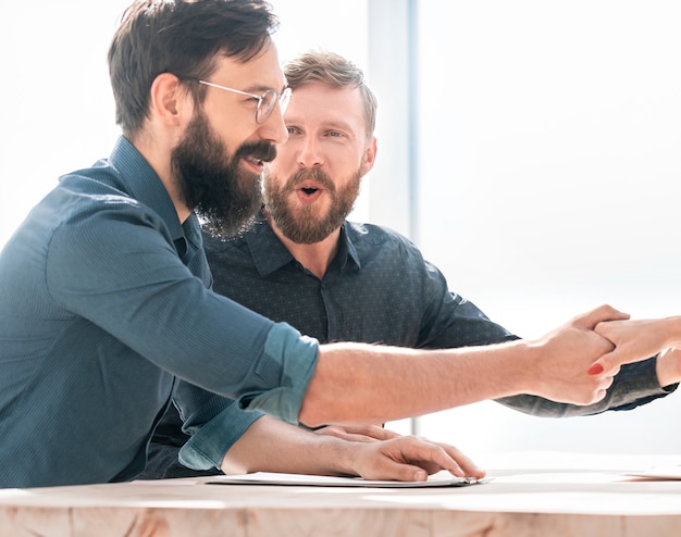 Employer shaking hands with a new employee during the interview . concept of cooperation