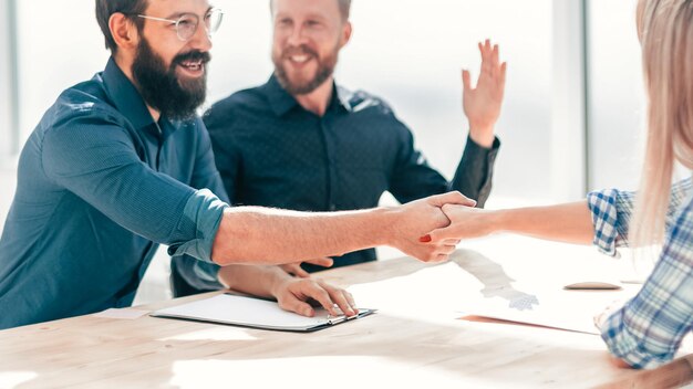 Employer shaking hands with a young woman during the interview. concept of cooperation