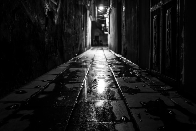 Empty alley amidst buildings in city at night