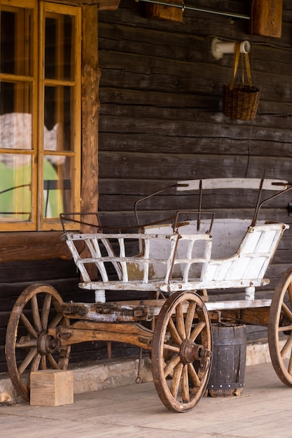 An empty antique carriage stands on a ranch in the wild West