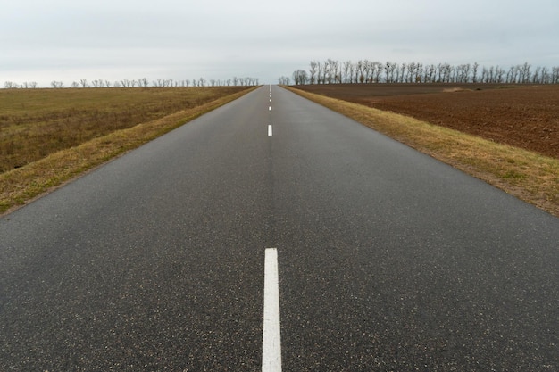 Empty asphalt road closeup against the sky Empty background space for text New asphalt concrete pavement in rural areas