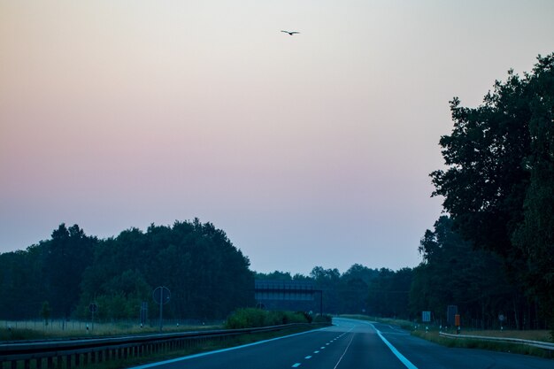 Empty asphalt road and field and blue sky with clouds.