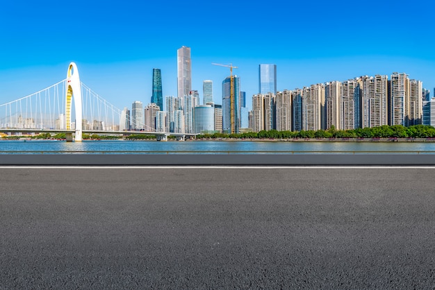 The empty asphalt road is built along modern commercial buildings in China's cities.