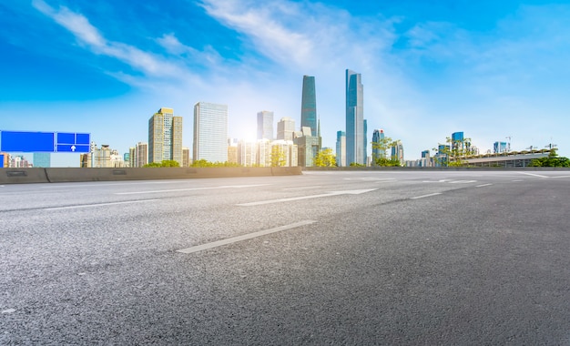 The empty asphalt road is built along modern commercial buildings in China's cities.