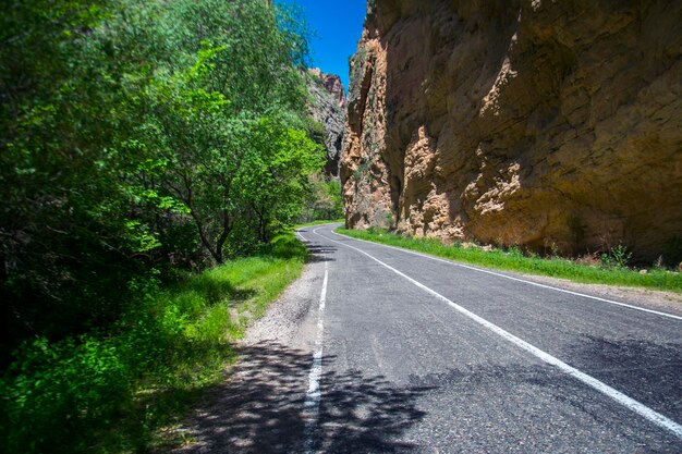 Foto strada vuota di asfalto e rocce sotto il cielo