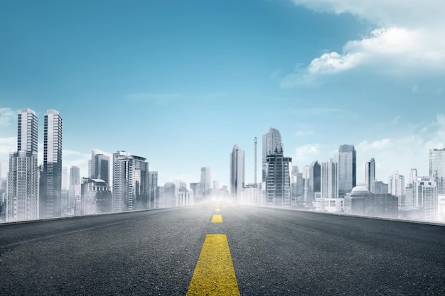 Empty asphalt road towards modern city with skyscrapers building