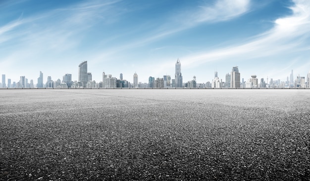 Empty asphalt road with cityscape of shanghai in blue sky