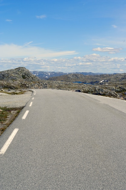 ノルウェーの山々の空の秋の道。