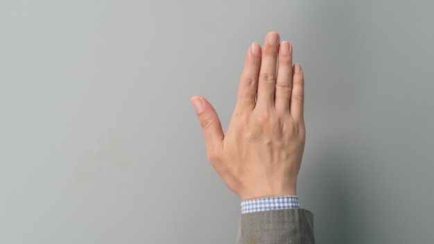 Empty back hand and five finger count in grey suit color on grey background. Businessman topic.close up photo and studio shooting.