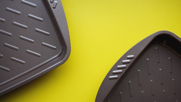 Photo empty baking tray. view from above on yellow background. copy space photography.