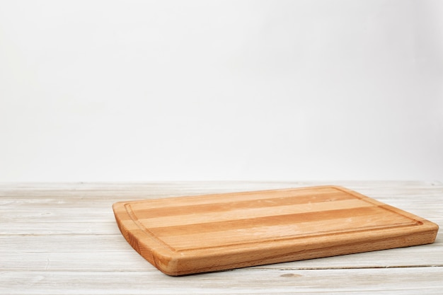 Empty bamboo cutting board on a white wooden