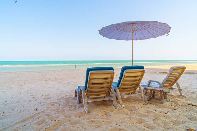 海の海の景色を望む砂の上の空のビーチチェア