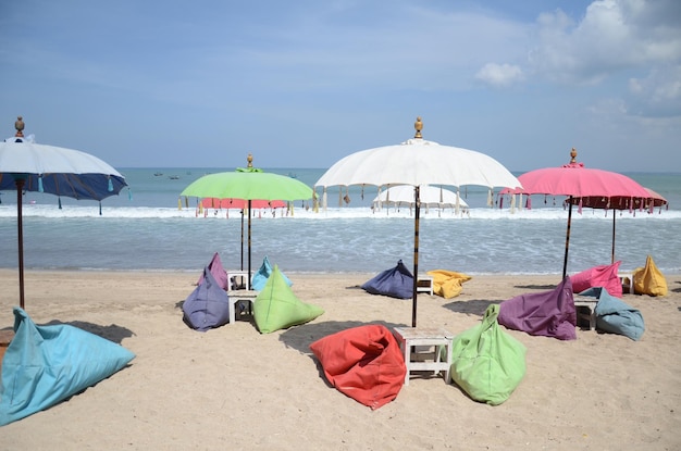 Пустой пляж с яркими волнами серфинга стульев палатки и солнечным небом