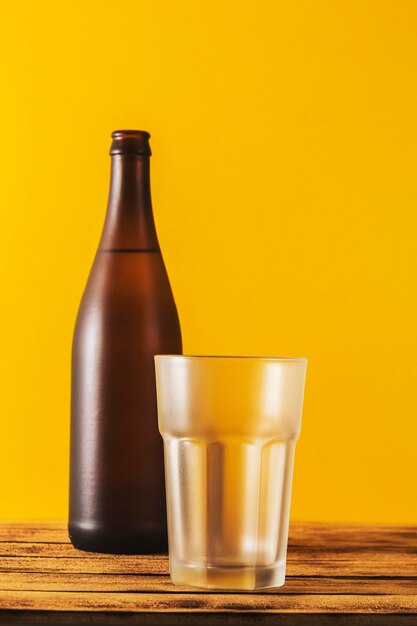 Empty beer glass bottle beer on a wooden background and yellow selective focus