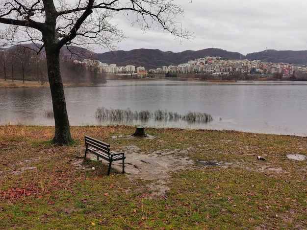 Foto panchina vuota accanto al lago contro il cielo