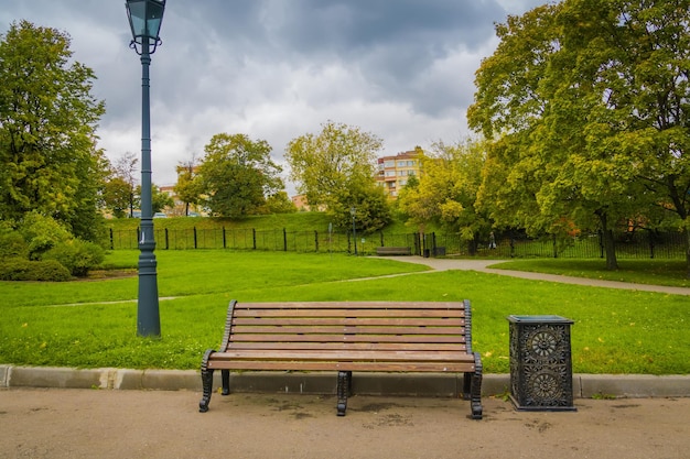 Empty bench in park against sky