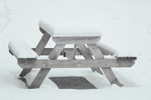 公園の誰もいないベンチが雪で覆われている