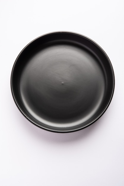 Empty black ceramic serving bowl, isolated over white or gray surface