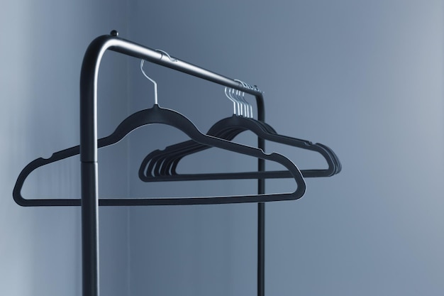 Empty black clothes hanger on blue  wall background