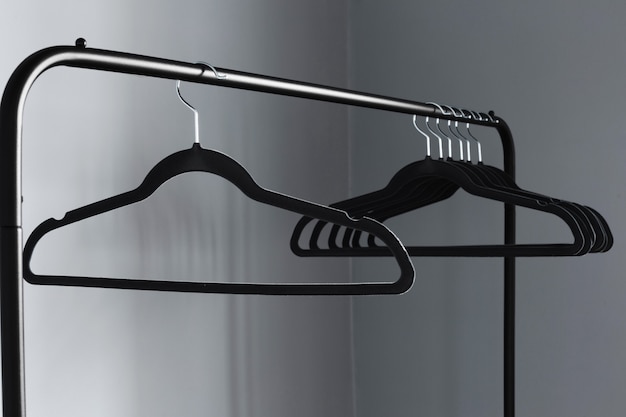 Photo empty black clothes hanger on gray wall background