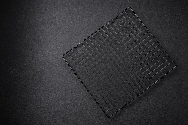 사진 어두운 콘크리트 배경에 디저트를 붓기 위한 빈 검은색 금속 주방 창살