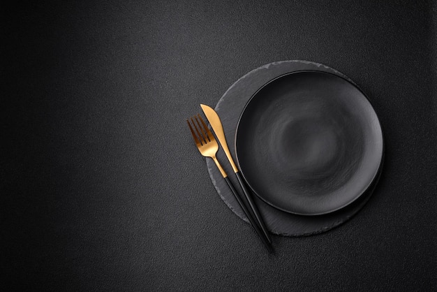 Empty black plate over dark stone background with copy space Top view