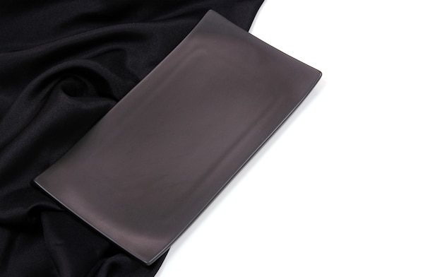 Photo empty black rectangle modern ceramic plate with silk tablecloth texture