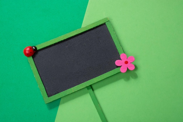 Empty blank notice board or bulletin board with flower and ladybird icon
