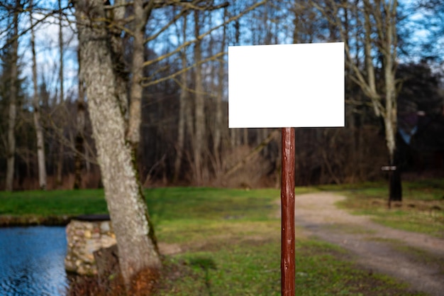 Empty blank sign board on a pole in a park