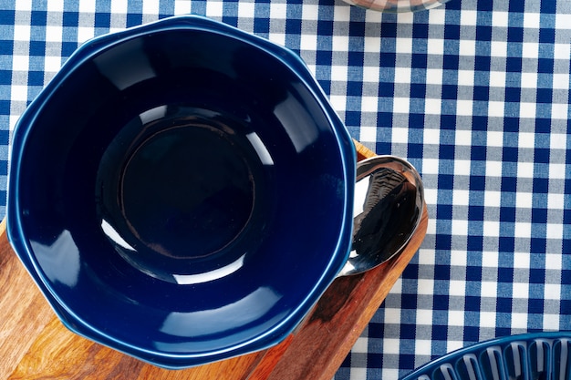 Empty blue ceramic bowl on kitchen table close up