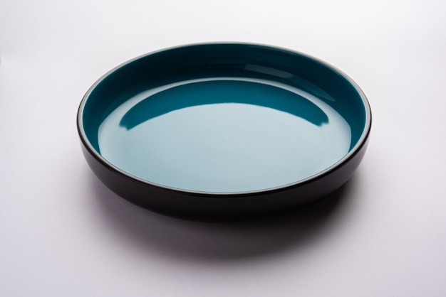 Empty blue ceramic serving bowl, isolated over white or gray surface