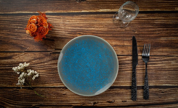 Empty blue plate and spoon on wooden background top view mockup