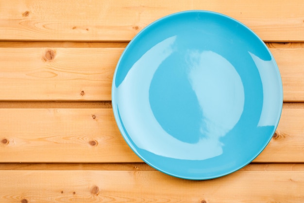 Empty blue plate on a wooden table