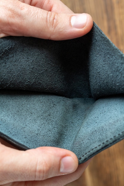 Empty blue wallet in man's hands