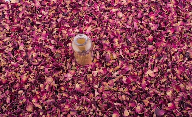 Empty bottle on dry rose petal background