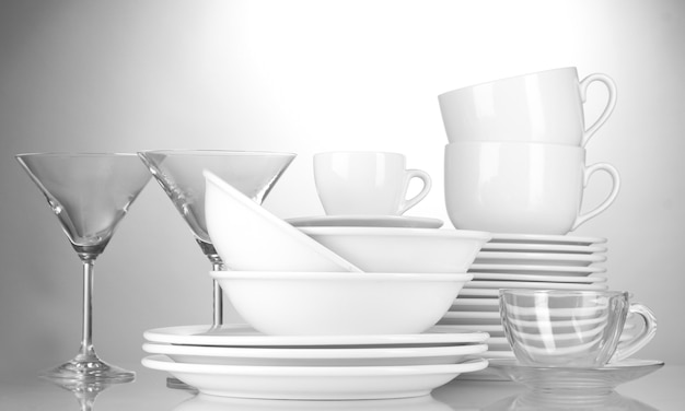 Empty bowls, plates, cups and glasses on grey