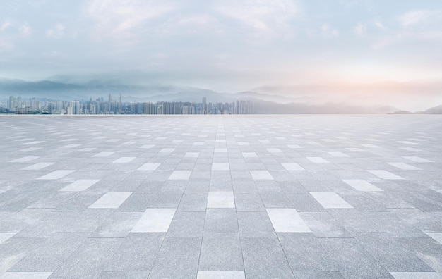 街のスカイラインと建築物を一望できる空のレンガ造りの床の広場