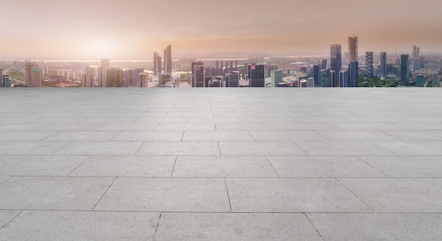 Empty brick floor with city skyline background