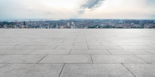 Empty brick floor with city skyline background