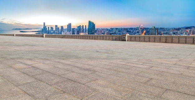 Empty brick floor with city skyline background