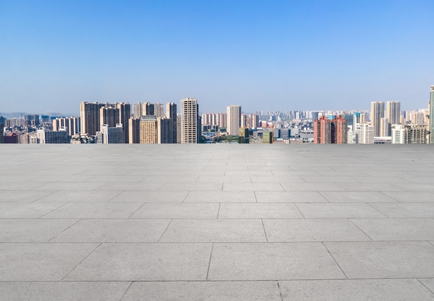 Empty brick floor with city skyline background