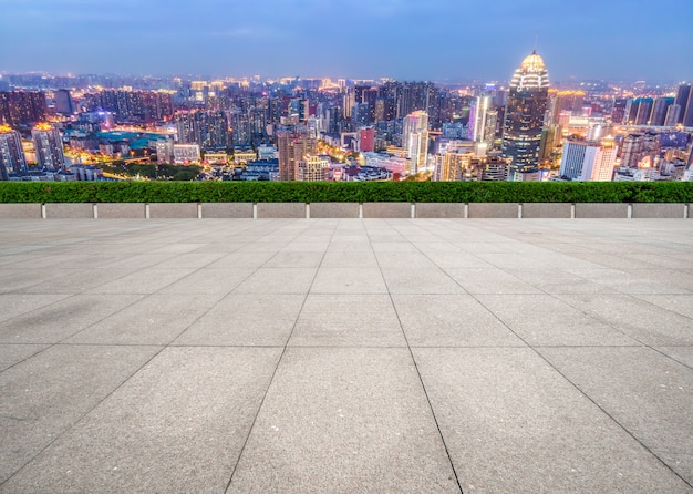 Empty brick floor with city skyline background