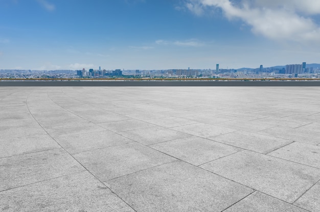 Empty brick floor with city skyline background