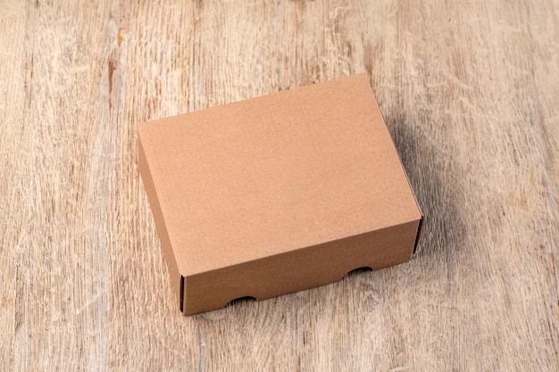 Photo empty brown carton box on the wooden table