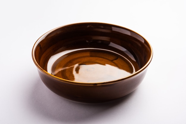 Empty brown ceramic serving bowl, isolated over white or gray surface