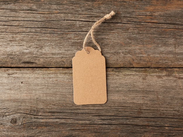 Empty brown paper tag tied with white string. Price tag, gift tag