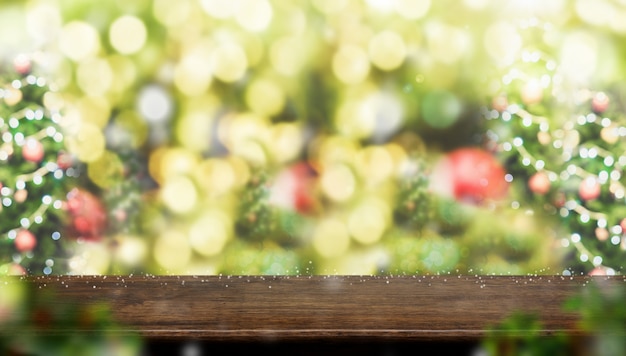 抽象的なぼかしと空の茶色の木のテーブルトップクリスマスツリーの装飾のボールと雪