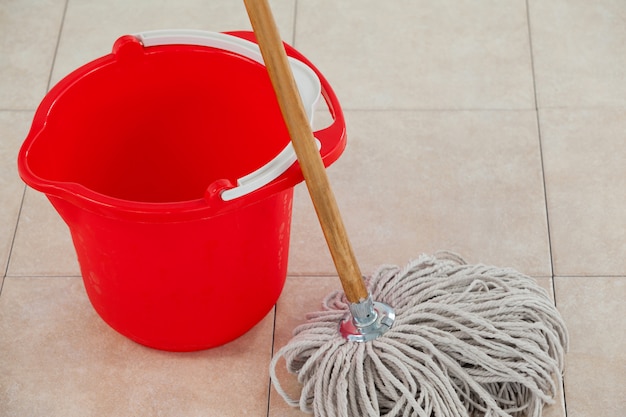 Empty bucket and mop on tile floor