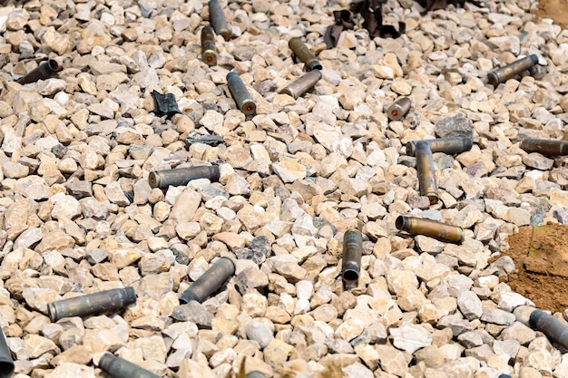 Empty bullet or cartridge casings spread on the ground. At the shooting range. Shotgun shell.