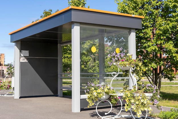 An empty bus stop decorated with beautiful flowers in pots and vases